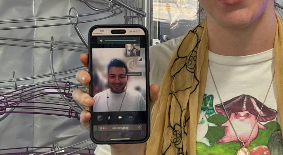 a woman holds a phone showing a facetime call with a man