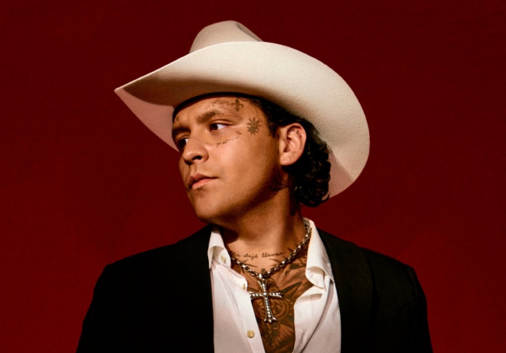 Latino man wearing a suit and cowboy hat.