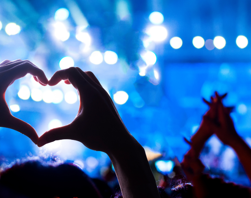 Concert attendees make heart symbols