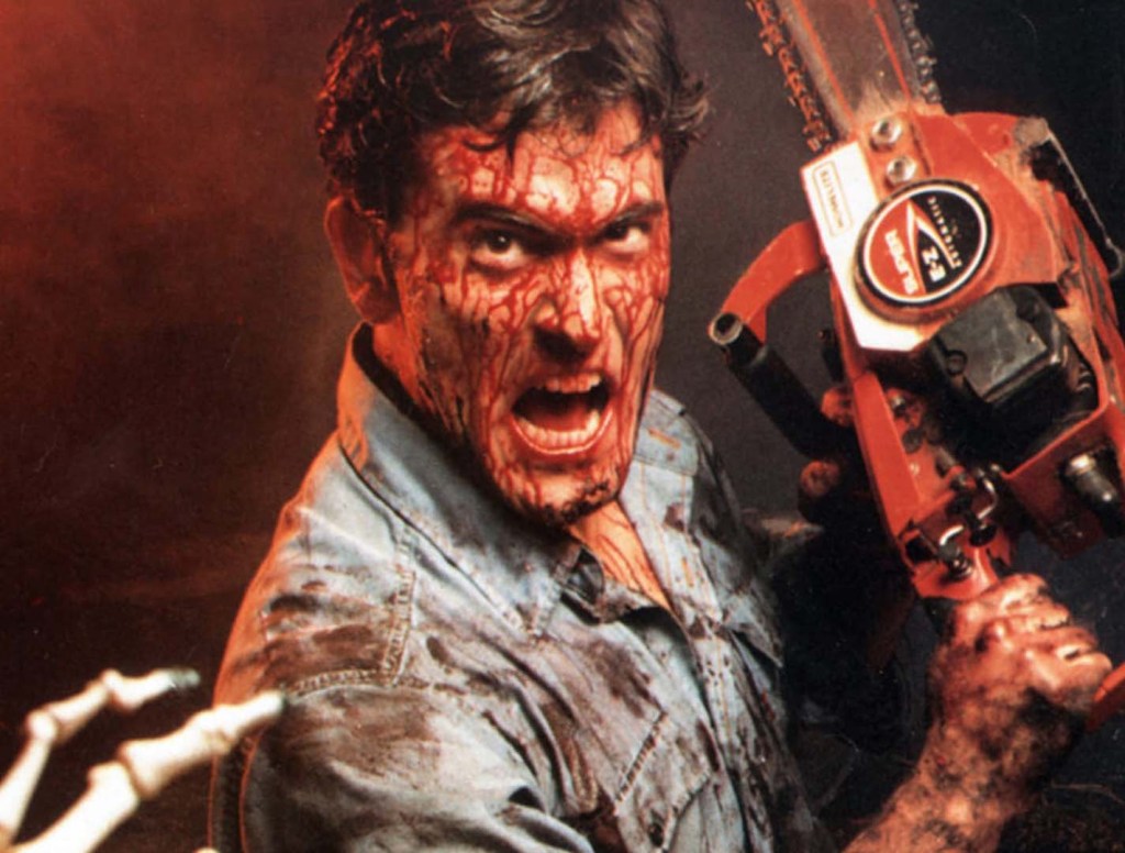 Actor Bruce Campbell holds a chainsaw while covered in splatters of blood.