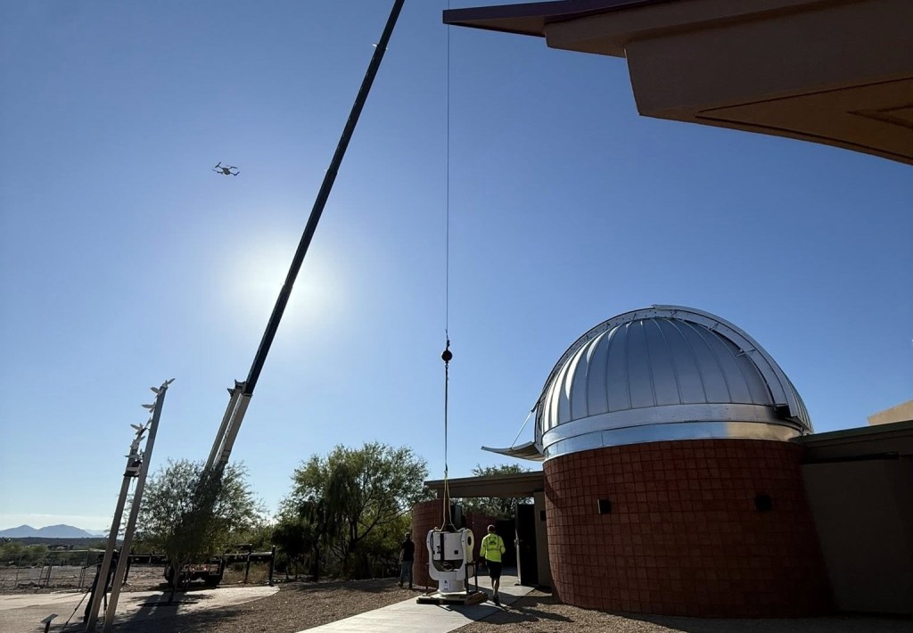A crane being used to install a telescope at an observatory.