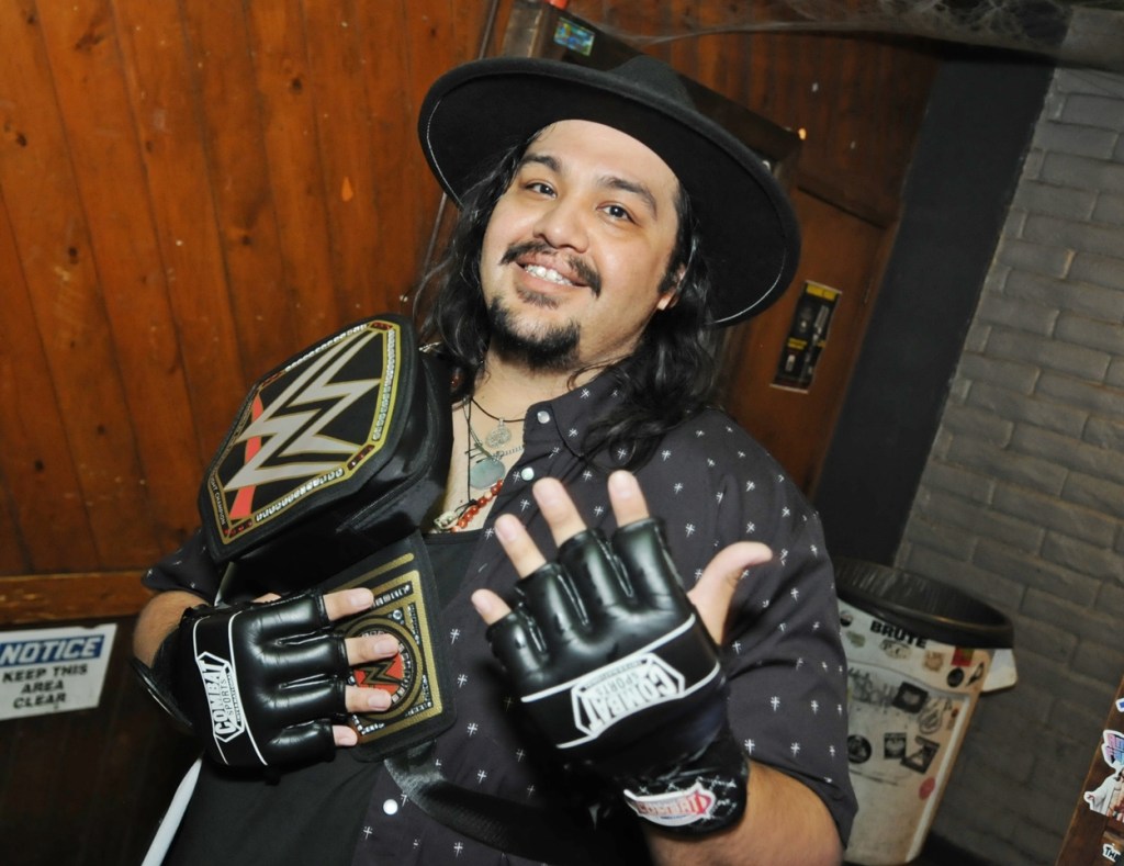 A long-haired Latino man dressed as The Undertaker from WWE.