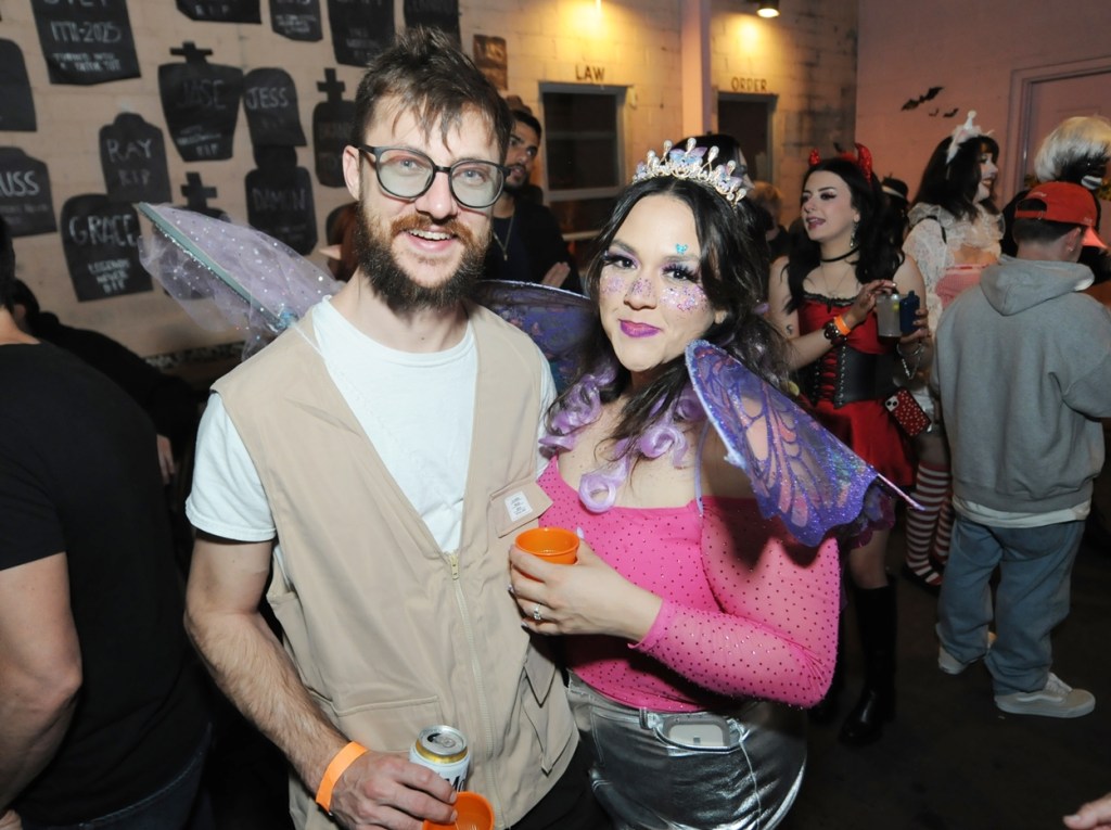 A man dressed as a butterfly collector next to a woman in regal costuming.