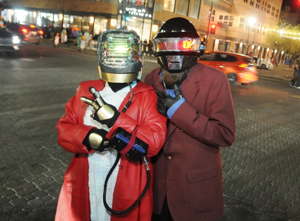 Two Halloween revelers dressed as Daft Punk on a streetcorner.