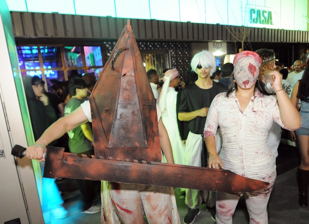Two people dressed as characters from "Silent Hill" outside a nightclub.
