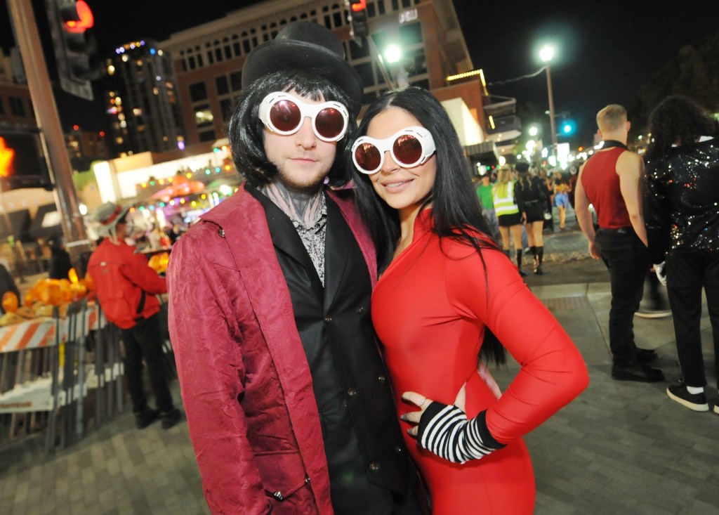 Two people dressed as characters from "Charlie and the Chocolate Factory" in a downtown area.