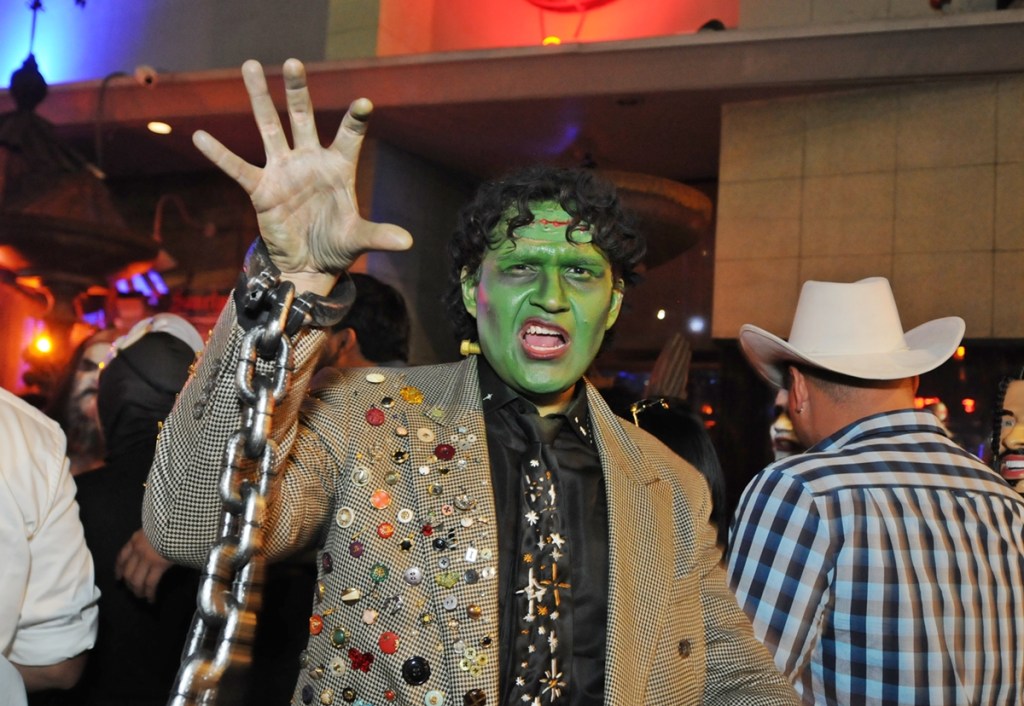 A young adult male dressed as Frankenstein's monster outside a nightclub.