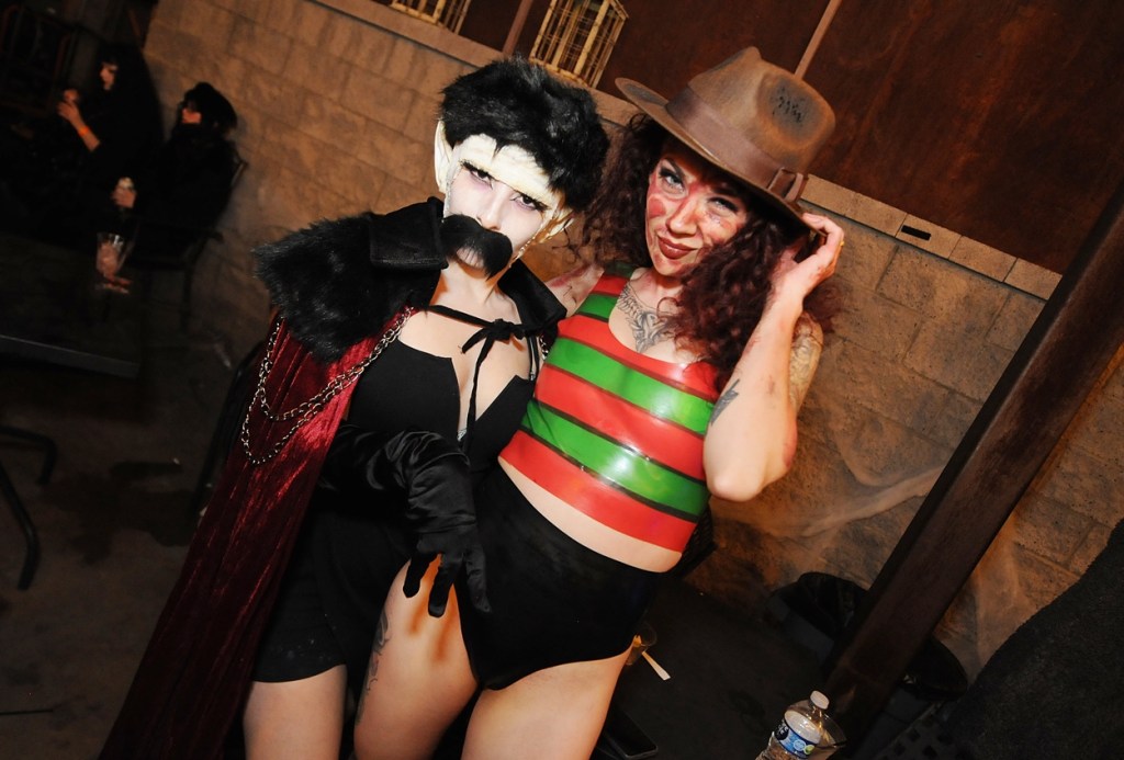A woman dressed in a Nosferatu costume next to a woman in a sexy Freddy Krueger costume.