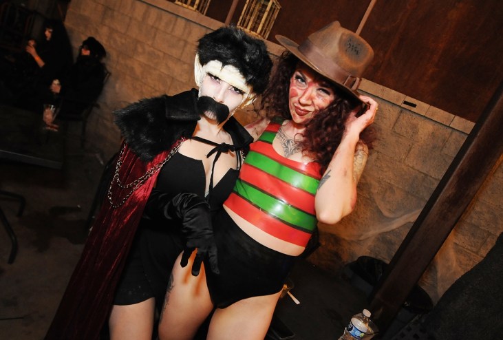 A woman dressed in a Nosferatu costume next to a woman in a sexy Freddy Krueger costume.