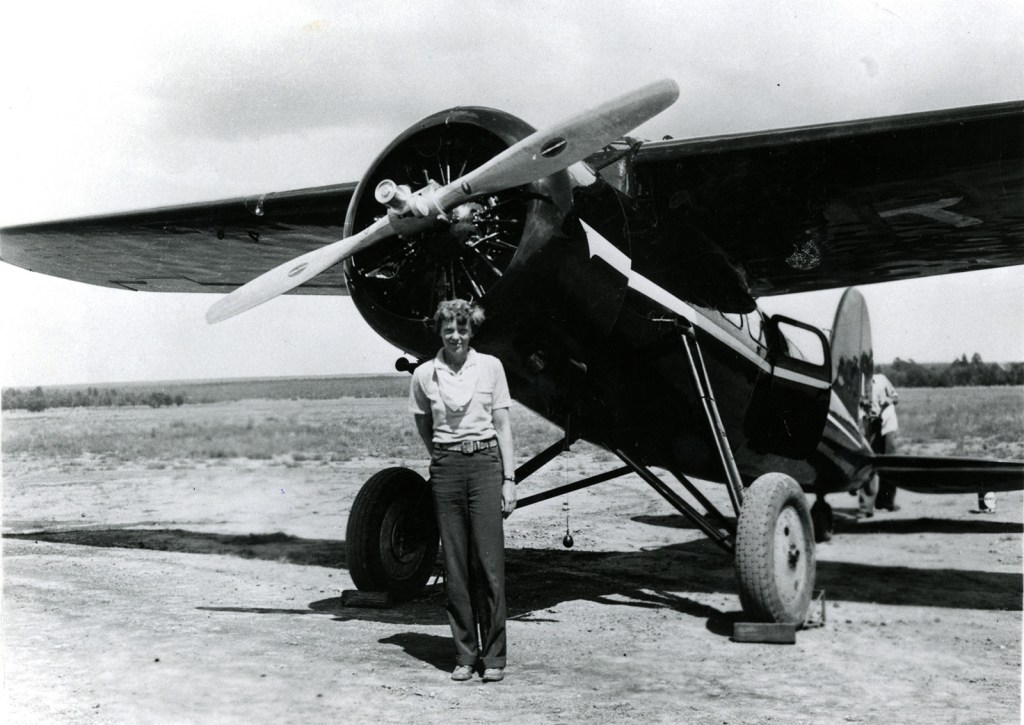woman standing next to an airplane.