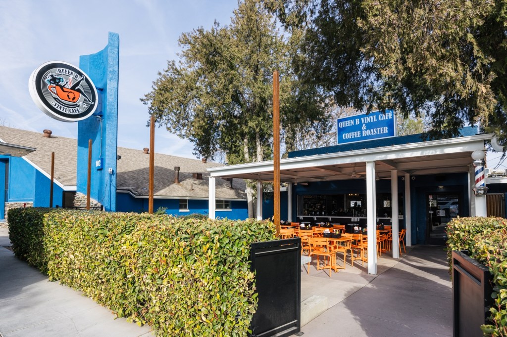 The exterior of a blue and white coffee house and cafe.