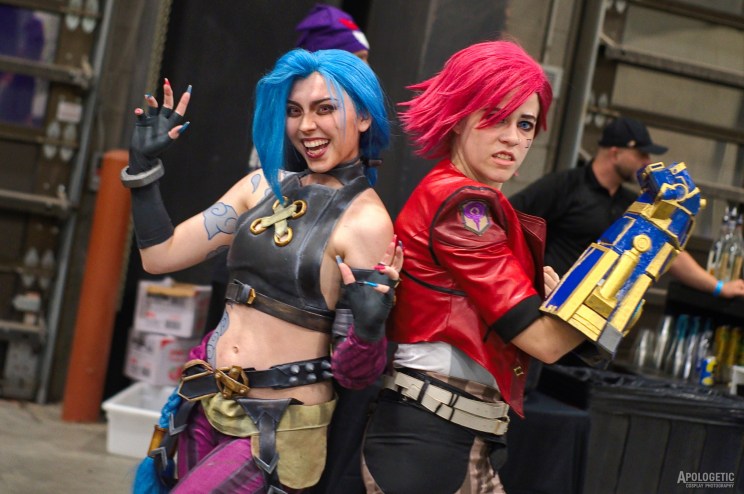Two female cosplayers standing back to back.