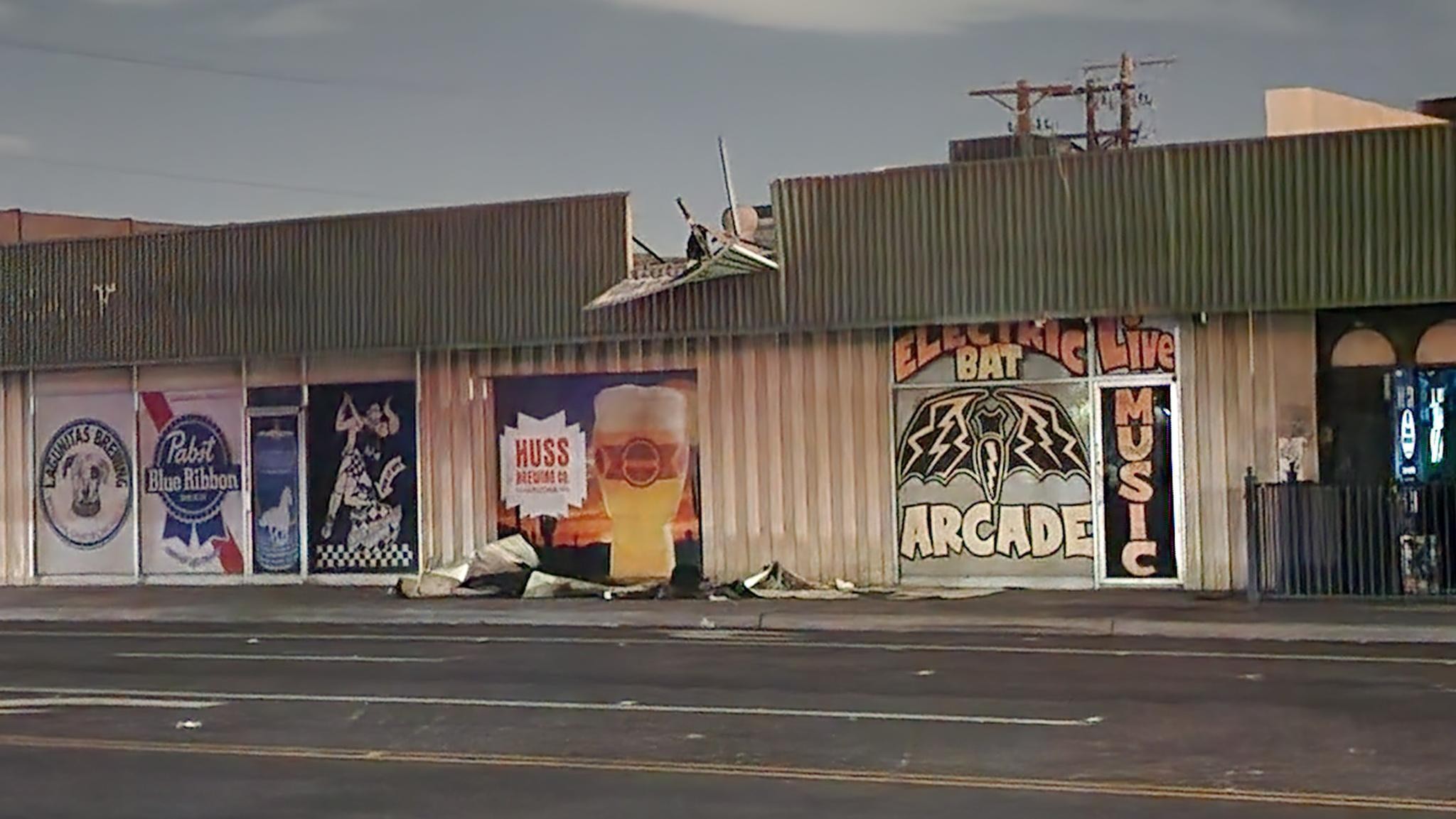 The side of a strip mall with a roof damaged from a storm.
