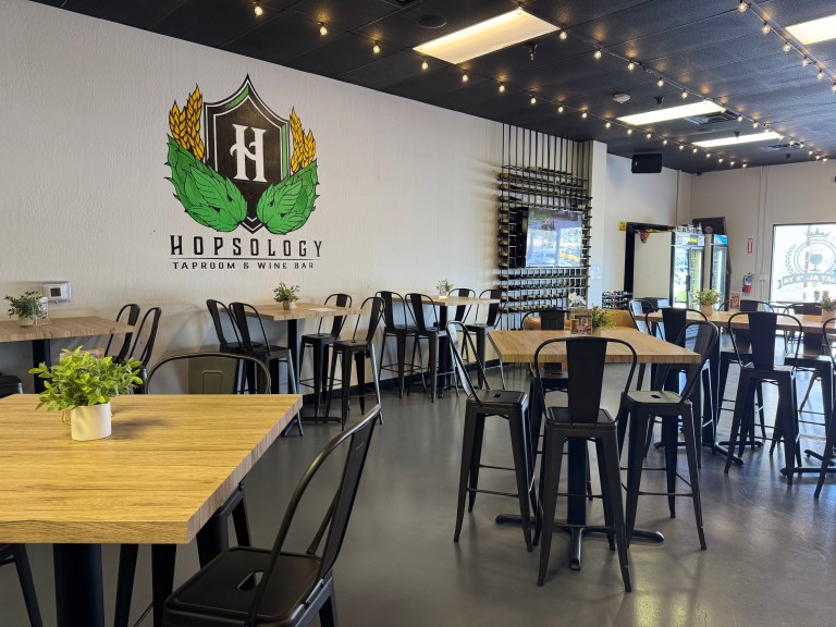 High top tables and chairs inside a taproom.