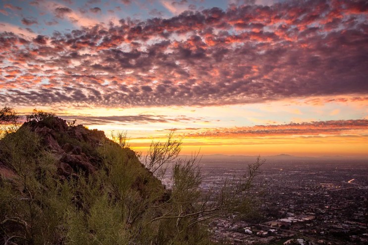 a sunrise on a mountain overlooking the valley of the sun