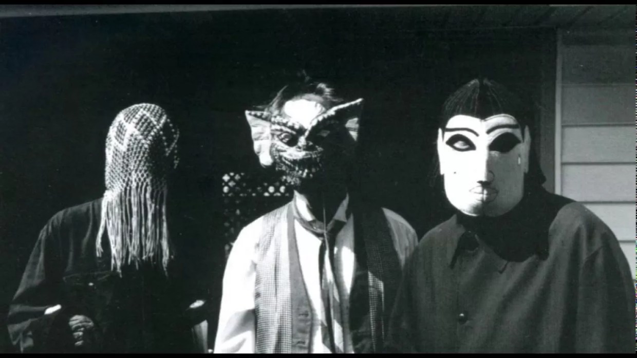 A black and white photo of three people in masks.