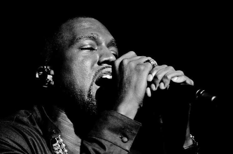 Kanye West singing into a microphone.