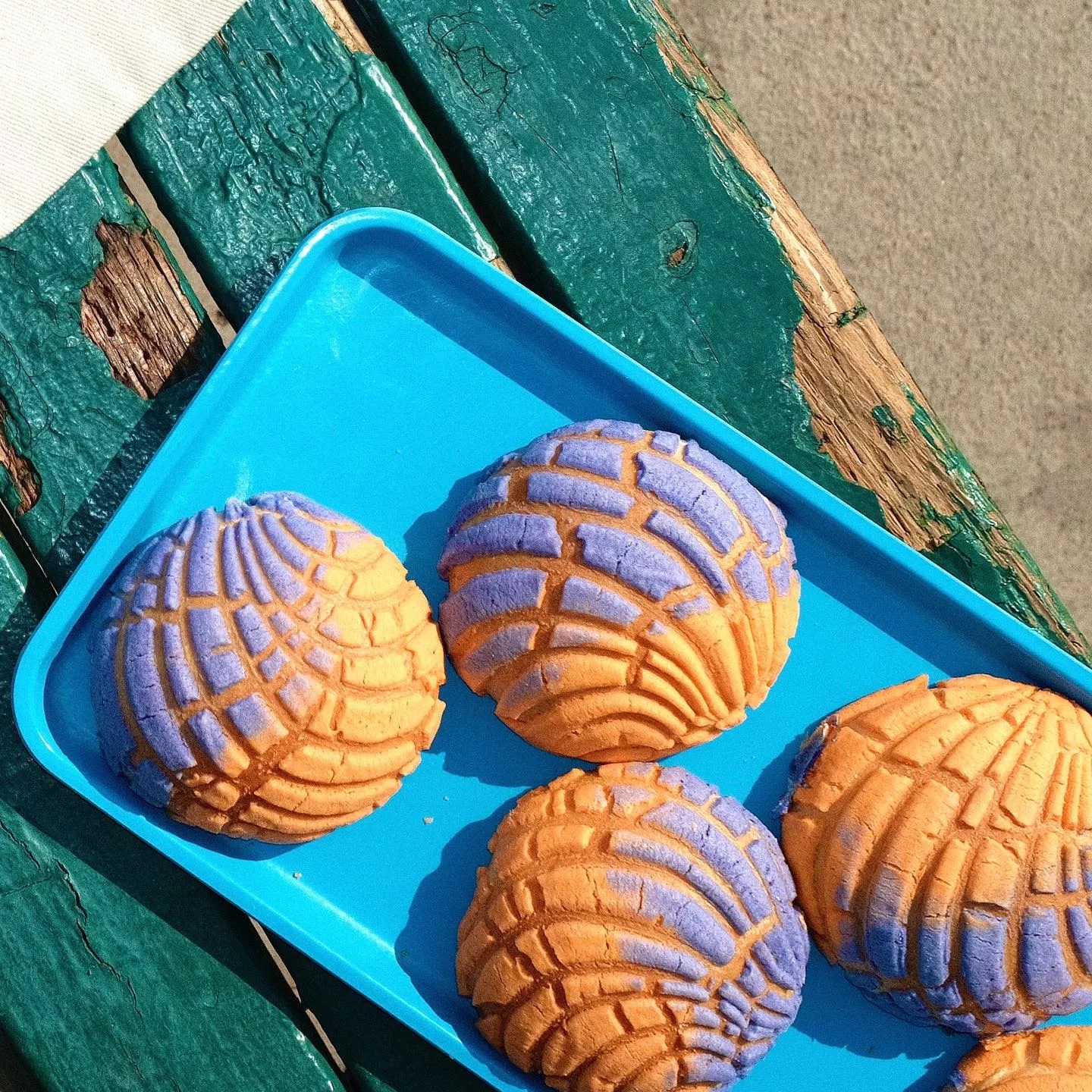 Tray of purple and orange conchas.