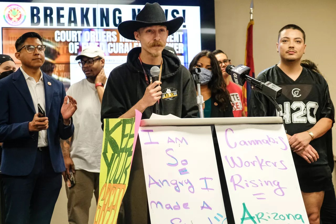 a man in a cowboy hat speaks at a press conference