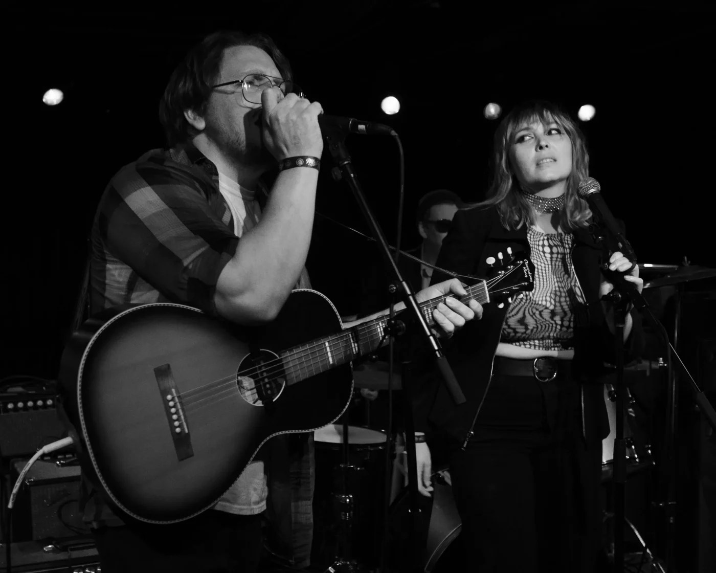 Man and woman in band perform on stage