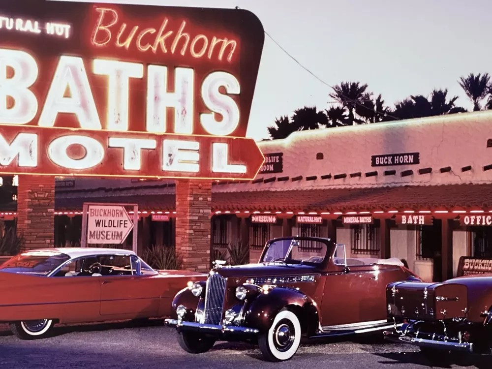 Old-fashioned cars in front of a motel.