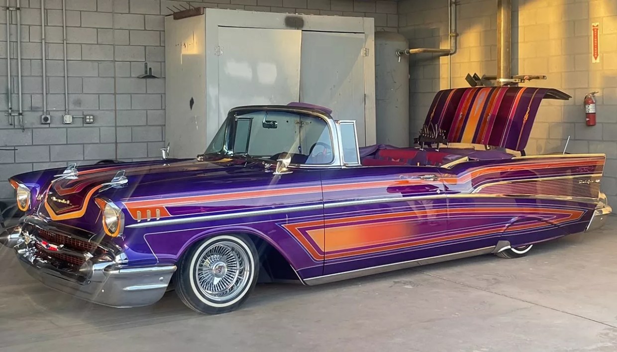 A vintage car painted purple and orange.