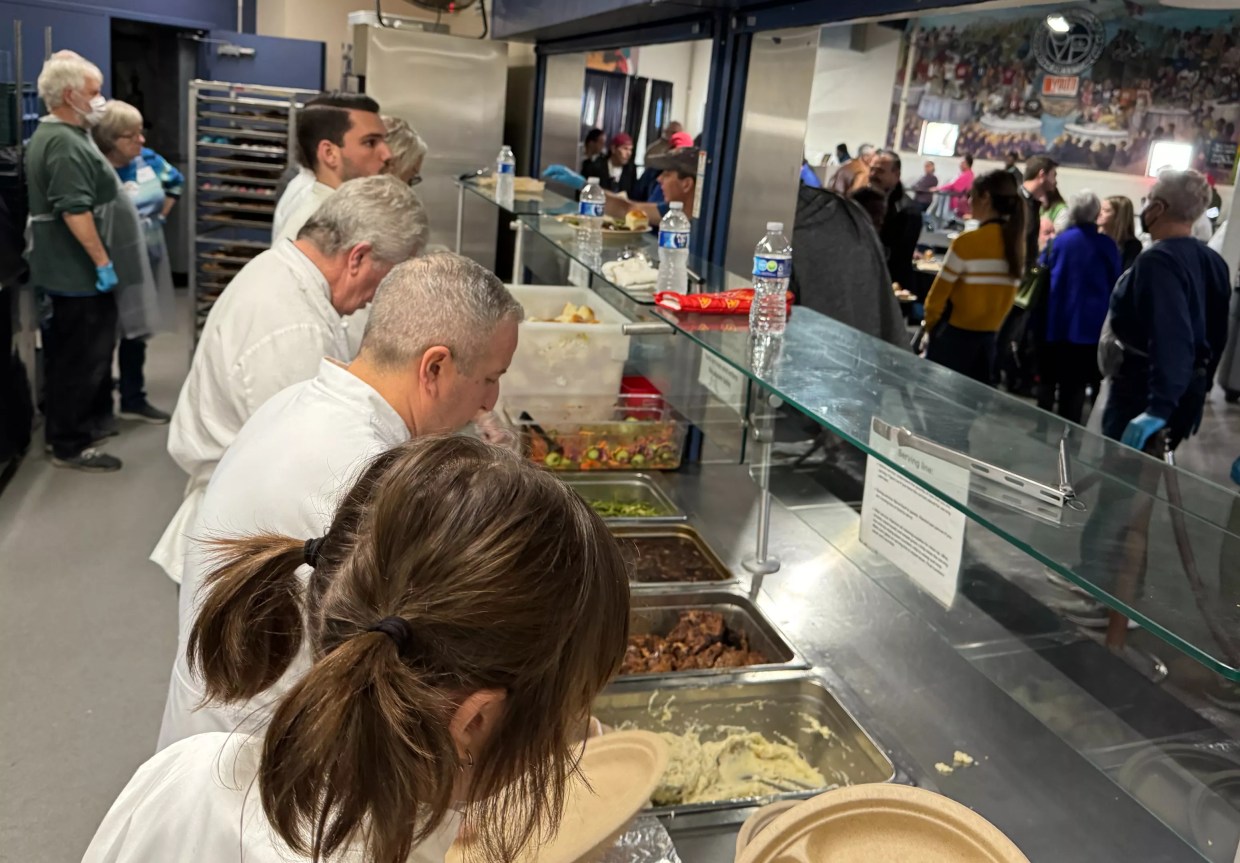 Chefs serve food at St. Vincent de Paul.
