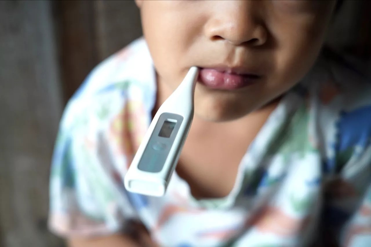 Sick boy with thermometer