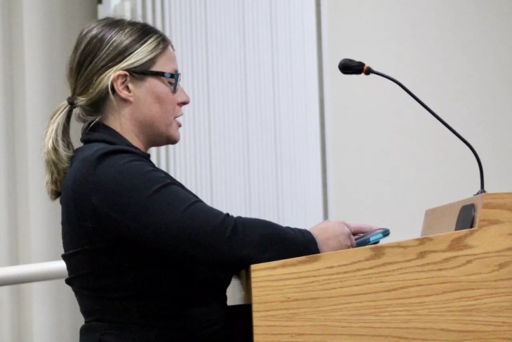 a woman speaks into a microphone at a podium