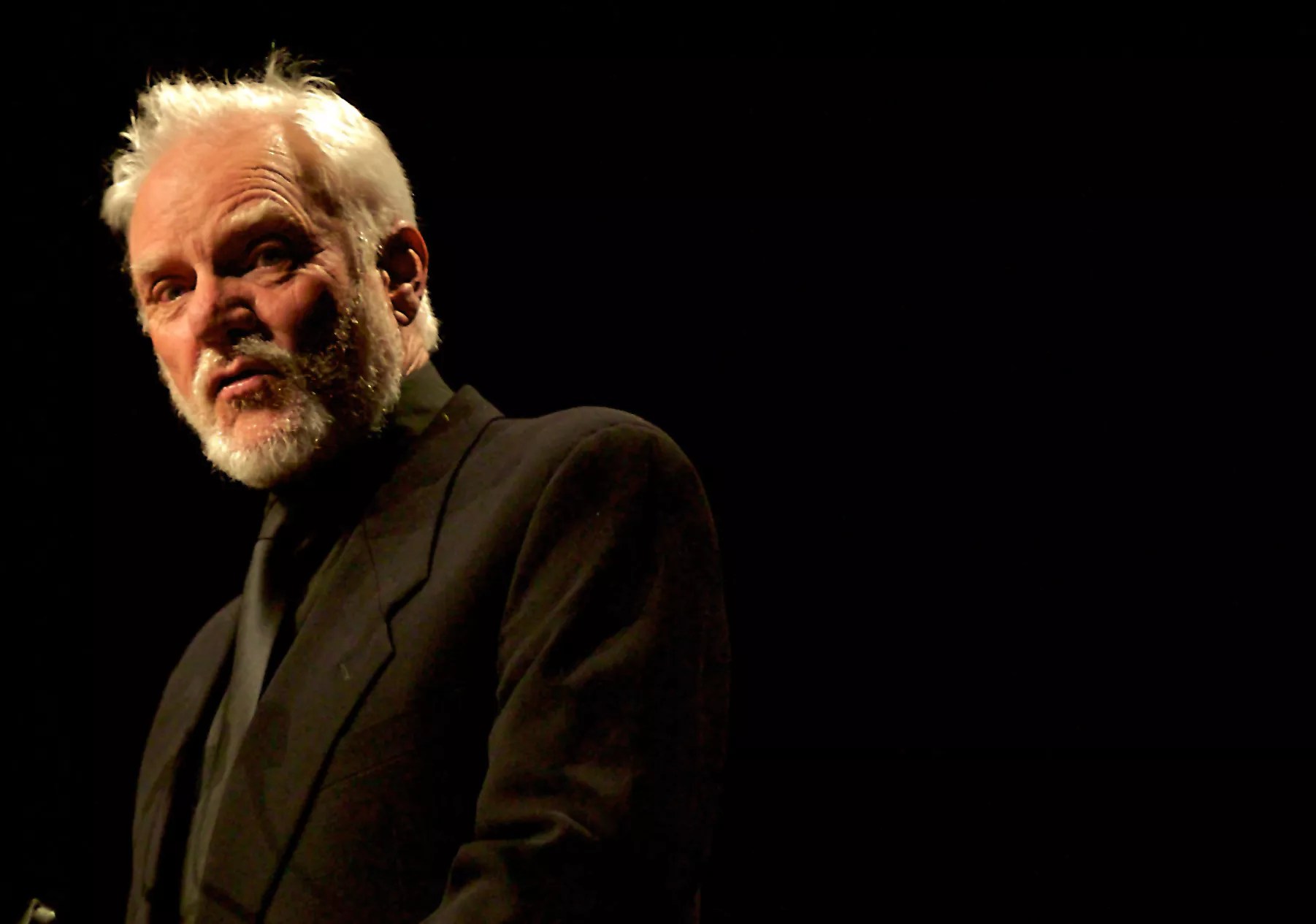 A white haired man wearing black.