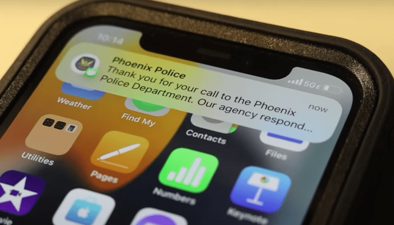 A phone with a text from "phoenix police"