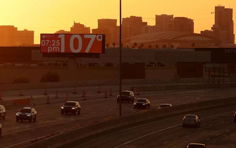 a phoenix highway with a billboard reading 107 degrees at 7:25 p.m.