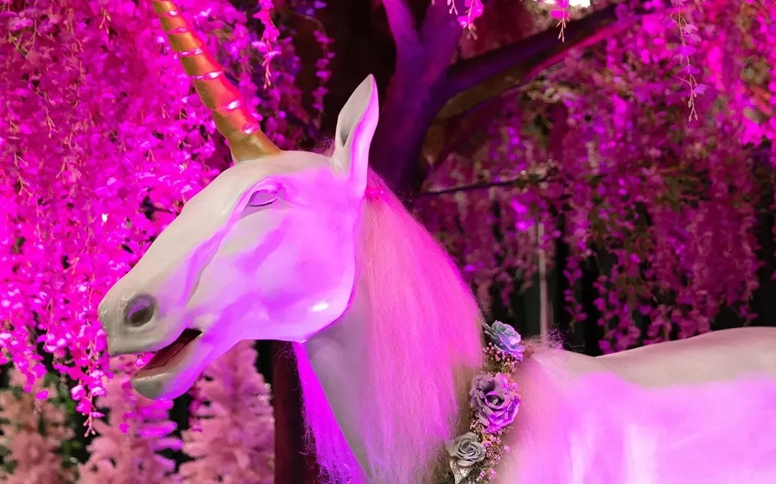 A unicorn statue in a pink room.