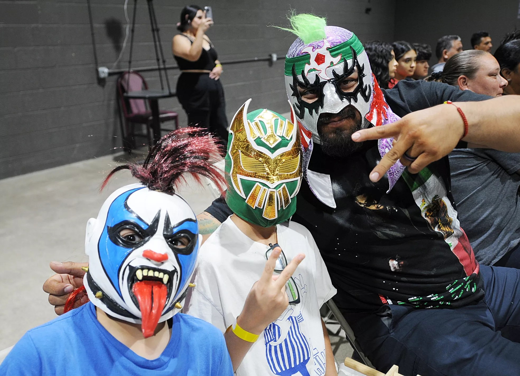 A trio of lucha libre fans in masks.
