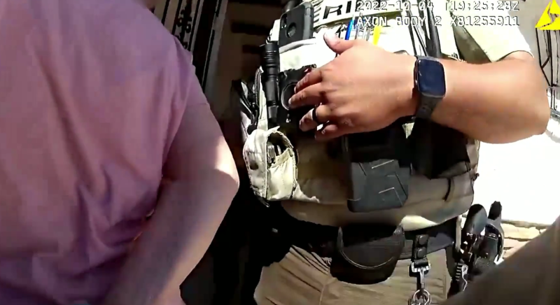body-cam footage showing a handcuffed old woman from behind next to a sheriff's deputy