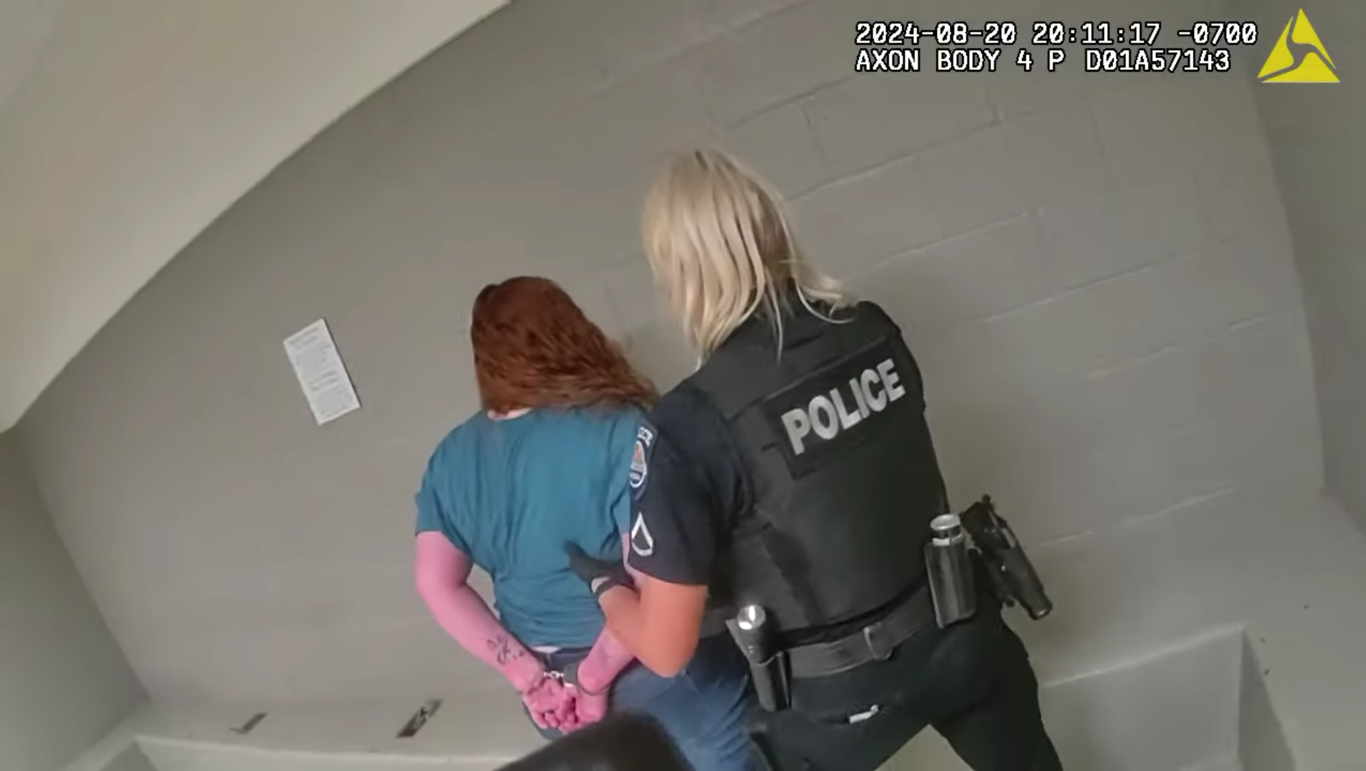 body cam footage showing a redhaired woman in handcuffs next to a blond, female police officer