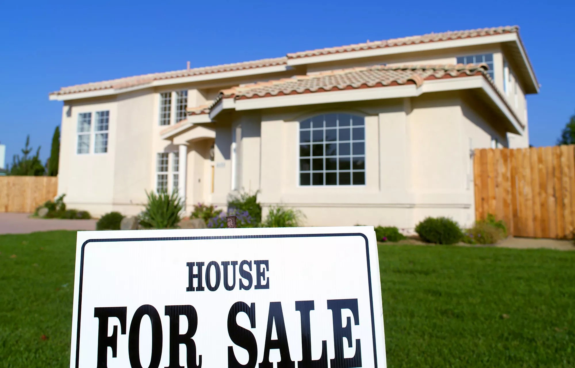 a house with a for sale sign out front