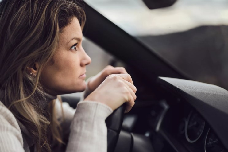 a woman staring intently out of her car