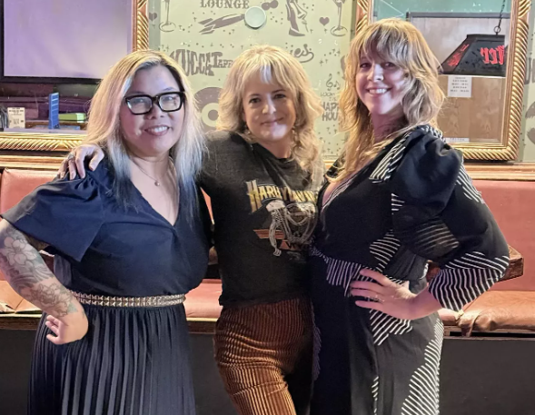A trio of women posing.