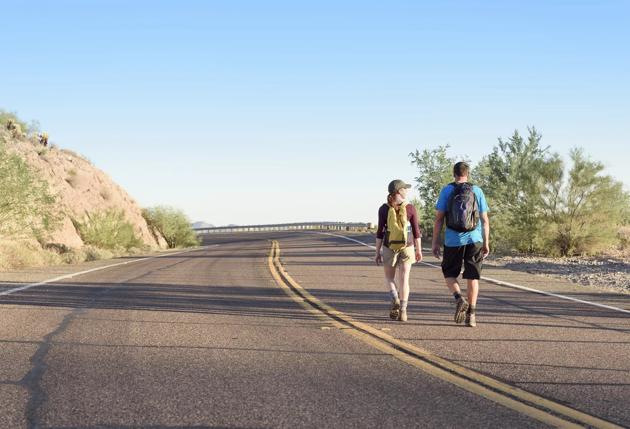 two people walking on an arizona road