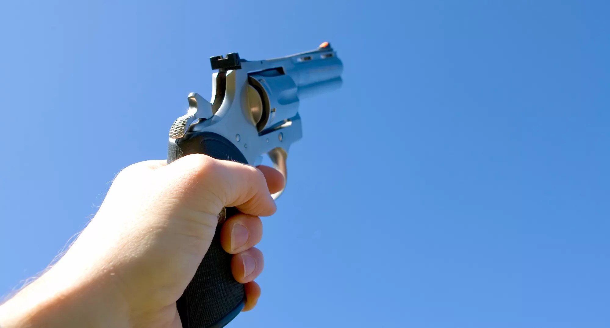 a handgun pointed at the sky