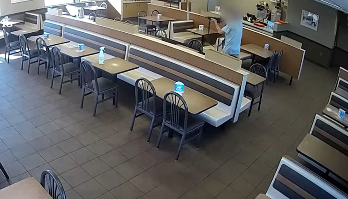a man in a fast food restaurant fires an assault rifle