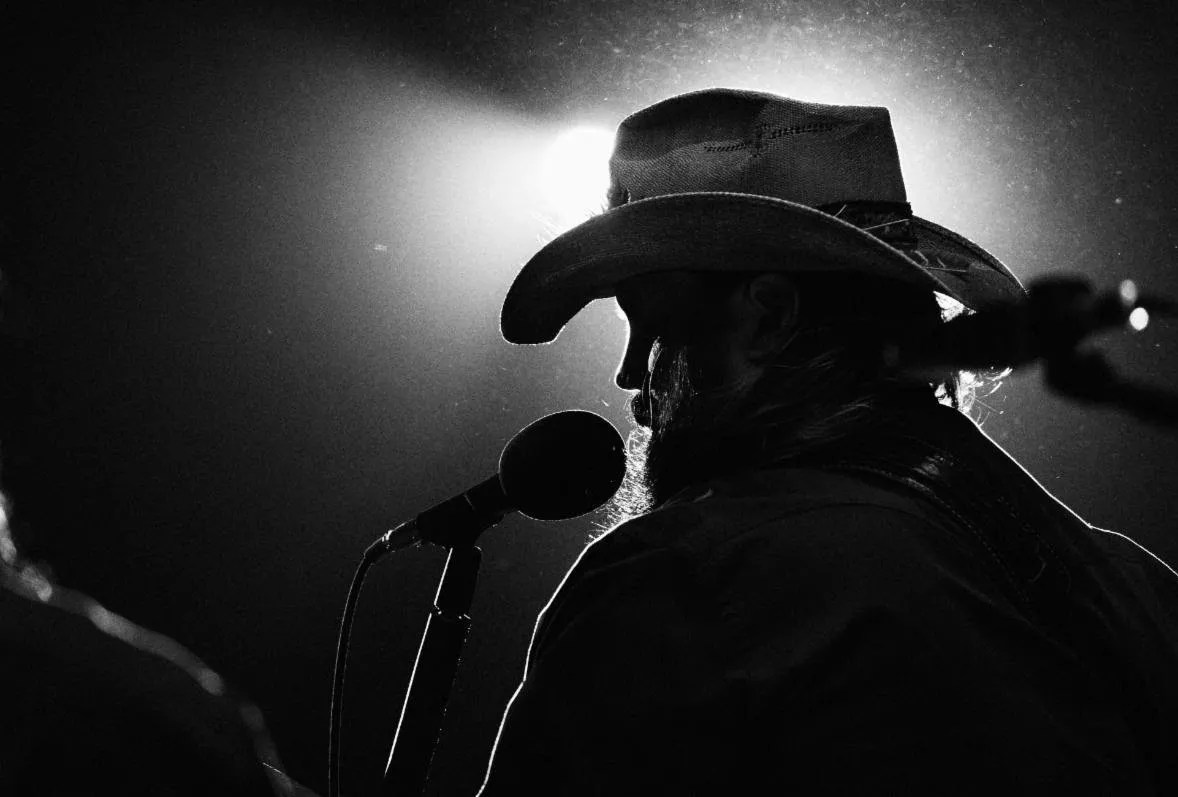 A black-and-white photo of a backlit singer.