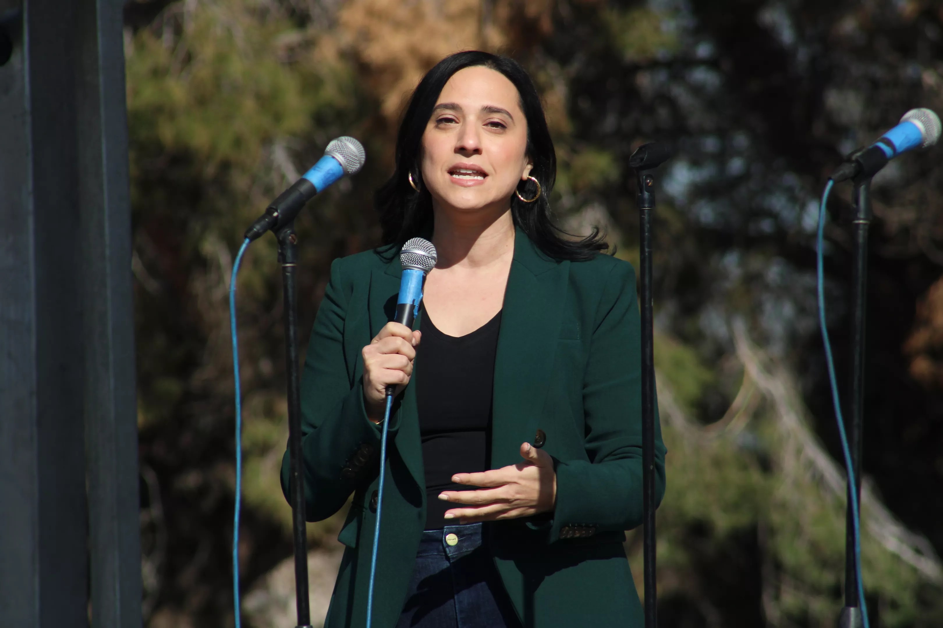 Arizona Rep. Yassamin Ansari speaks into a microphone at a Phoenix park