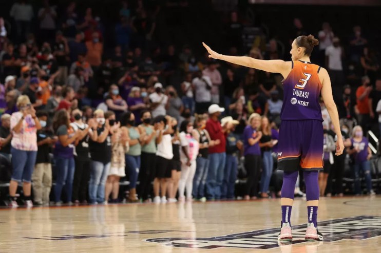diana taurasi waves to someone on a basketball court