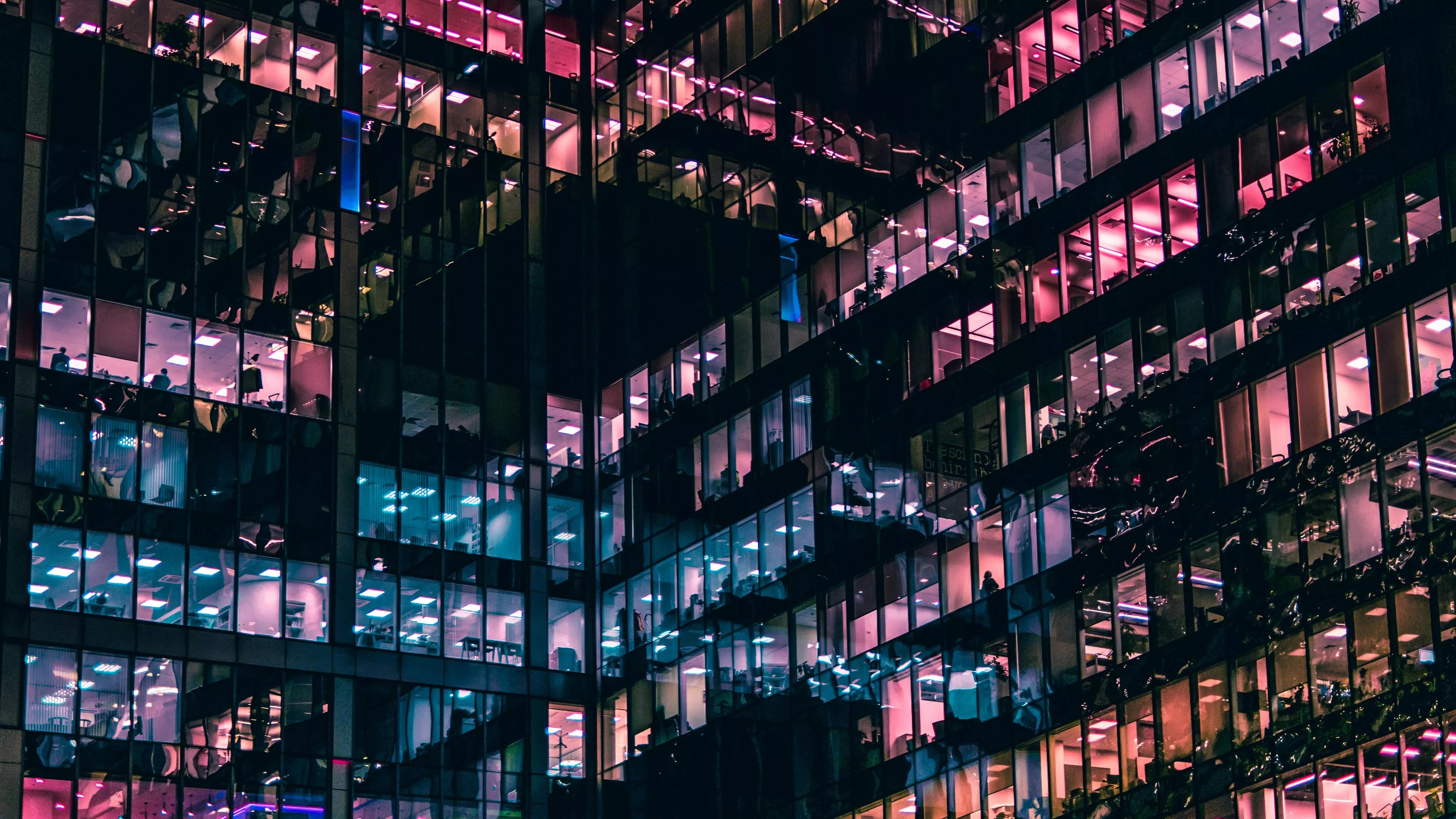 building with pink and blue lights reflecting