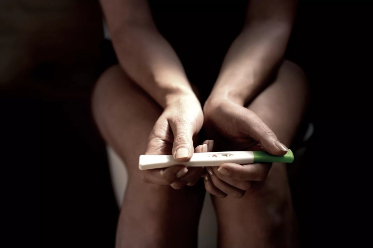 a woman's hands holding a pregnancy test