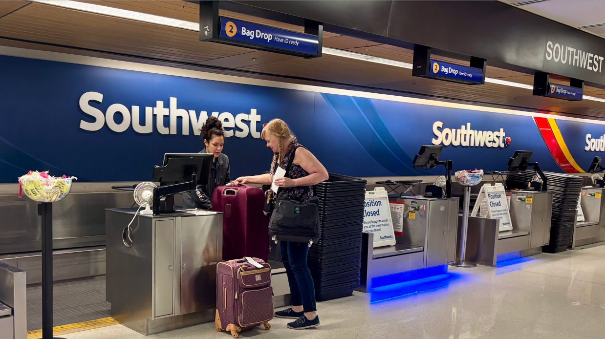 A woman checking bags at an airport.