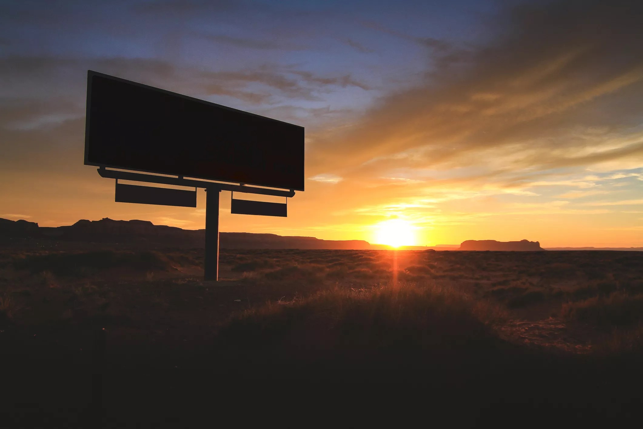a billboard backlit by an arizona sunset