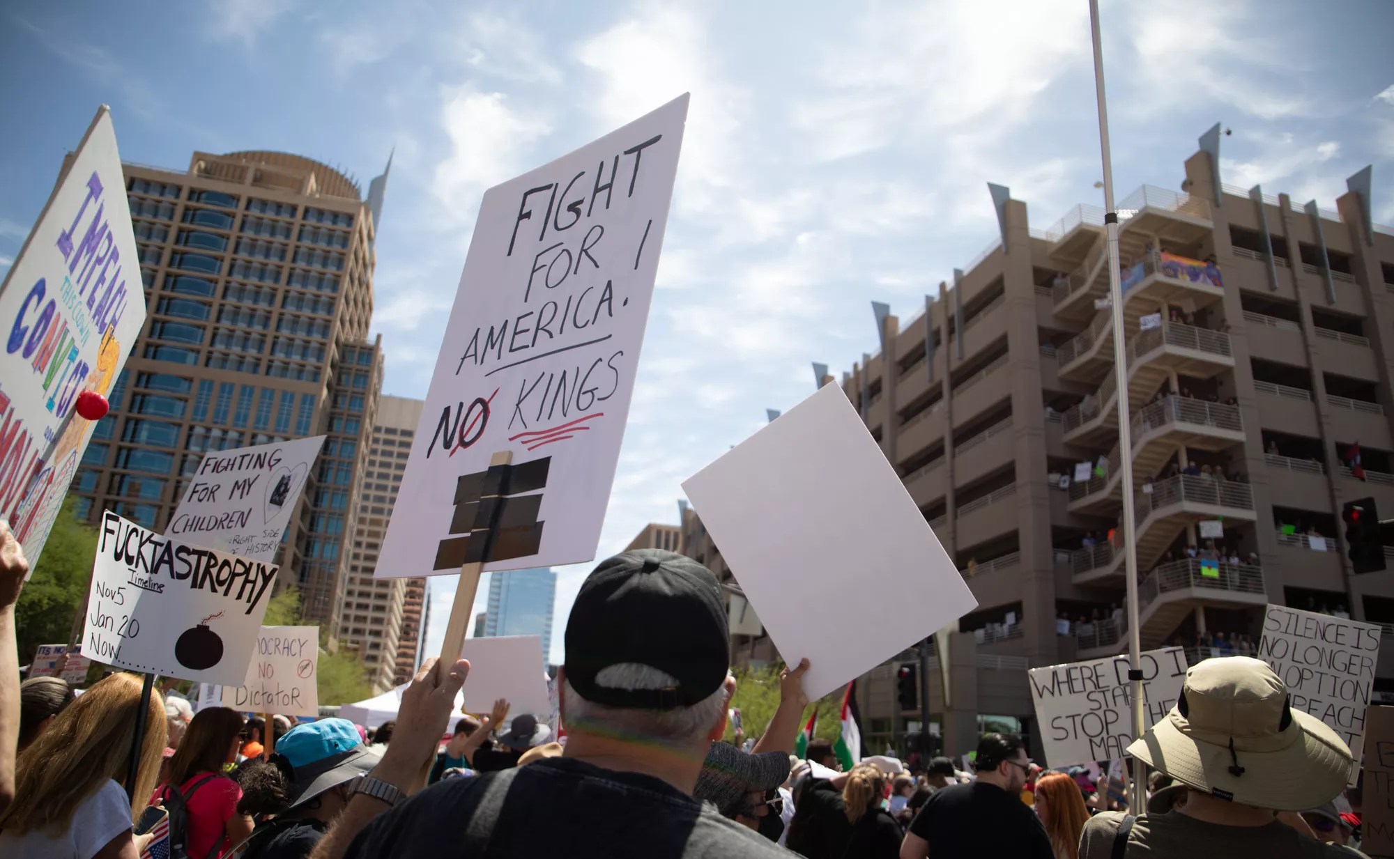 protesters hold signs in the air